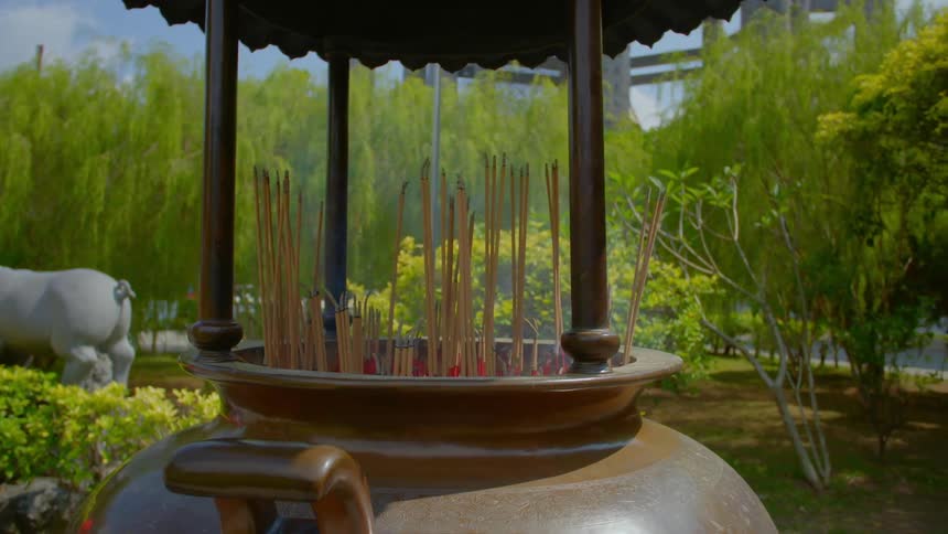 Incense burn in a pot in the middle of a garden