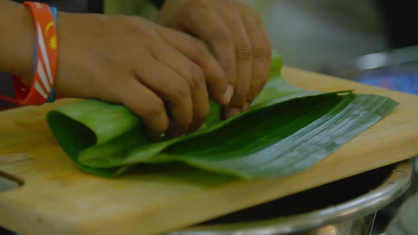 A woman making a wrap as she cooks