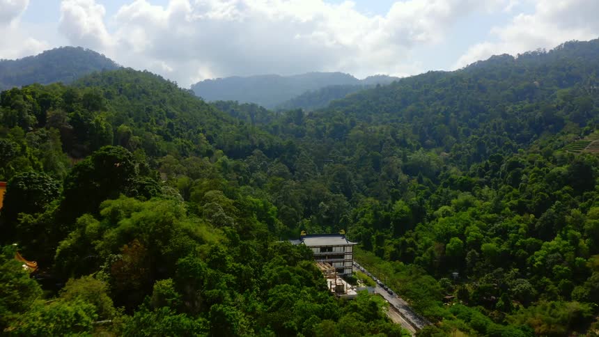 A village is nestled into the tree covered mountain slopes