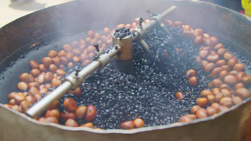 Food being stirred and cooked in a big metal pot