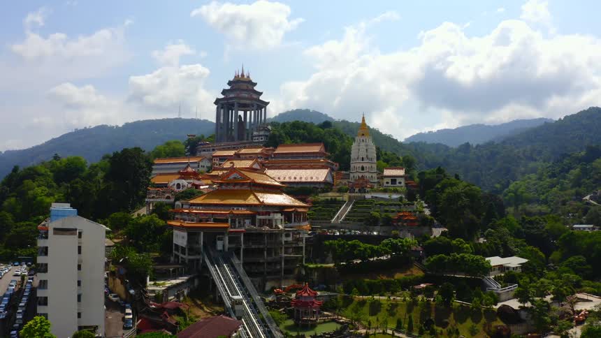 Aerial view of a temple and buildings in a city with cars lining the streets