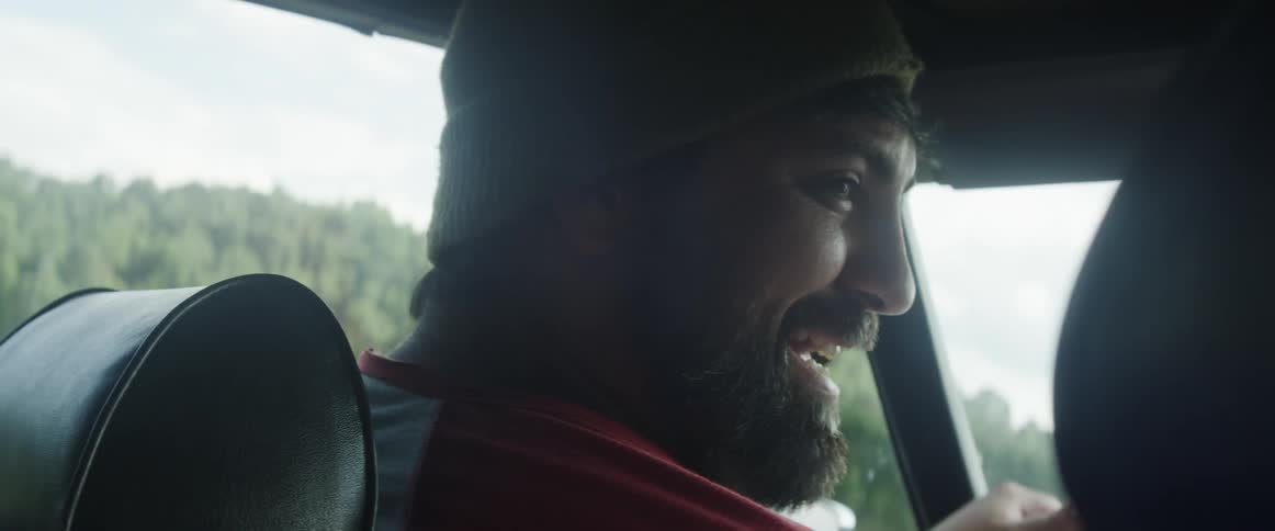 A man is driving a car and talking