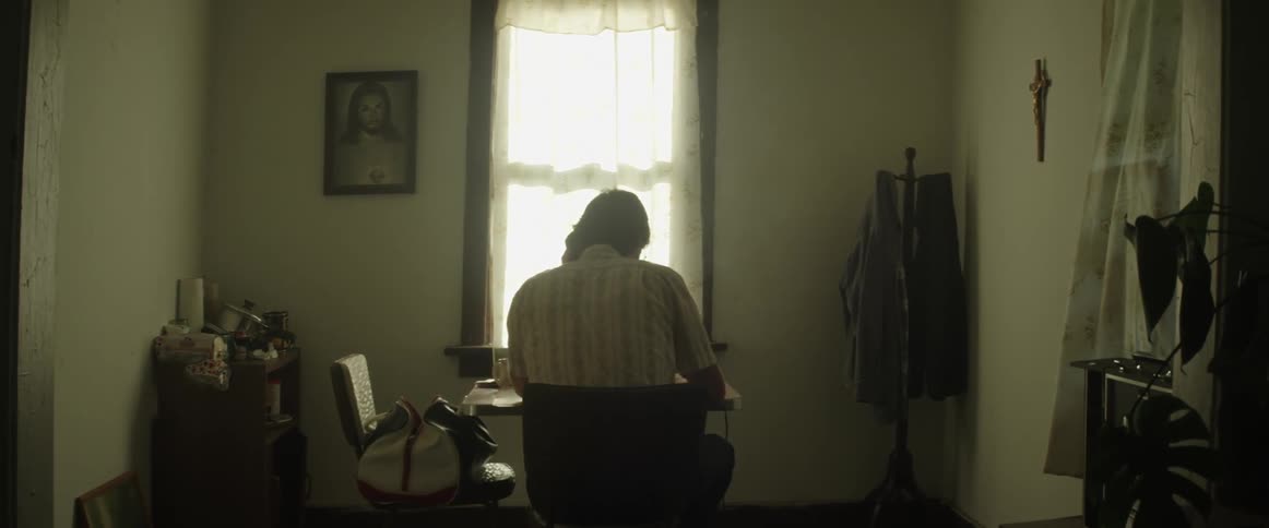 A person sitting at a desk looking down reading