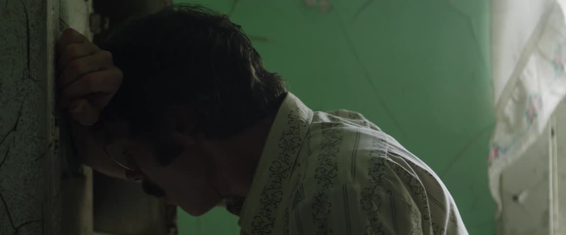 Sad man leans his head on his arm on a wall