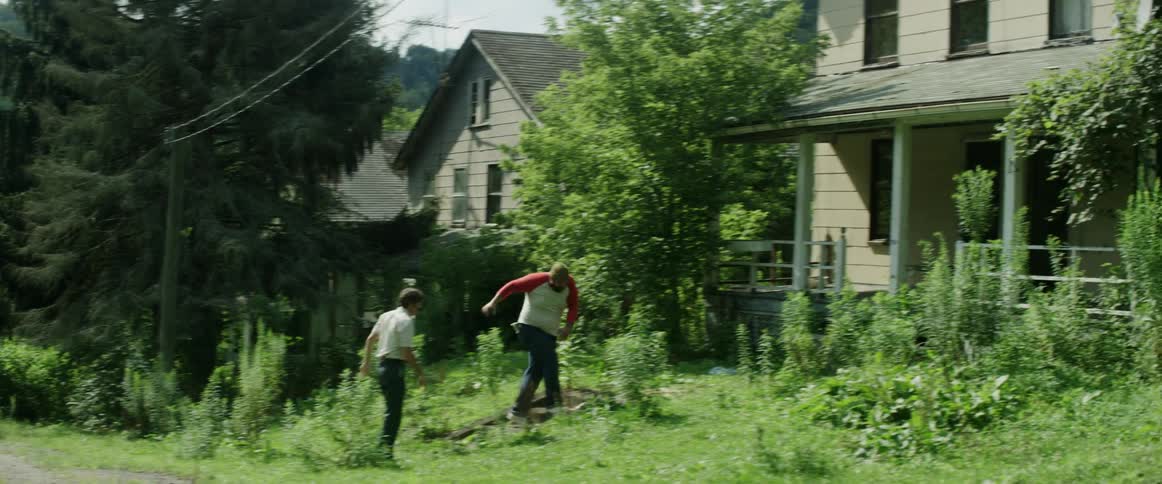 A man pushes and chases another man into the house