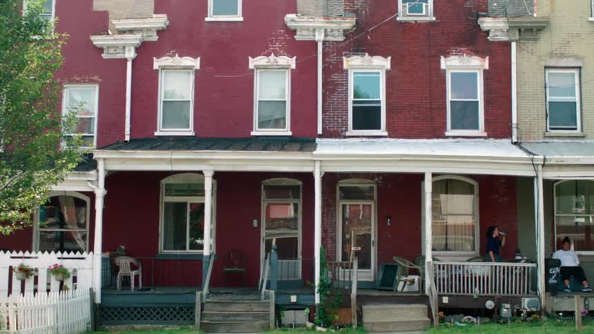 Two people are talking on a porch