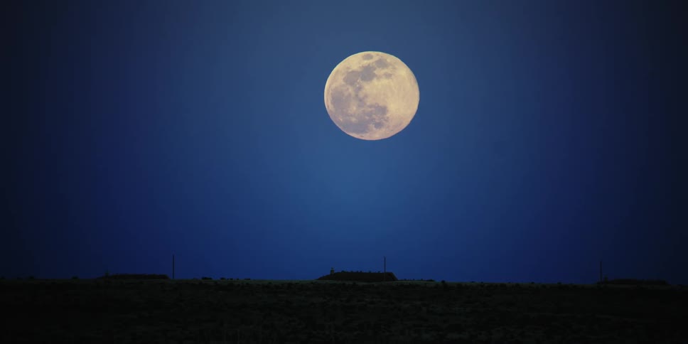 Full moon rises in the night sky