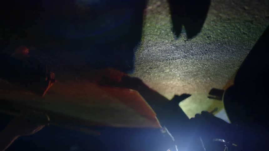 People are tapping against the surface with hands and sticks as lights flash