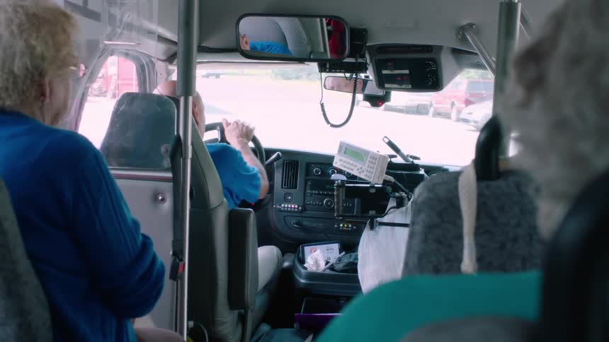 A bus driver uses a lever to close the door of his vehicle