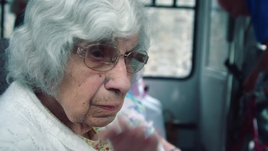 A woman sitting down slowly waves