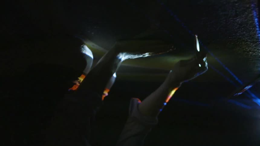 Hands are slapping and tapping against a surface as a light strobes