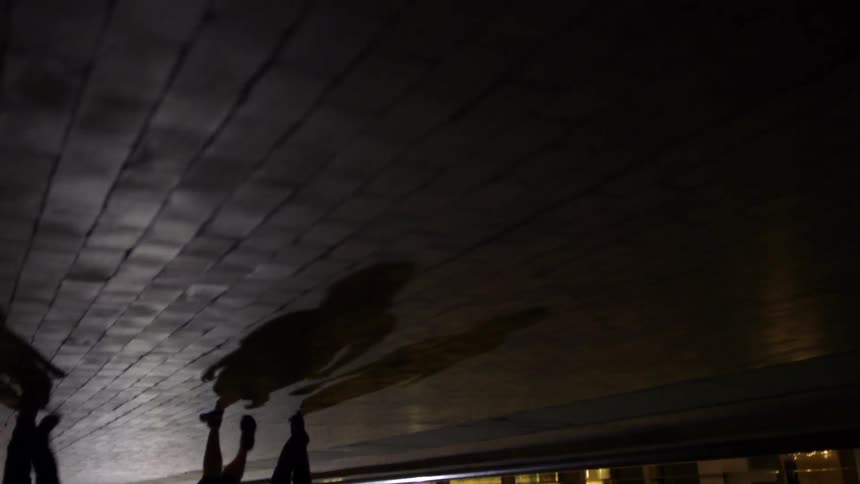Two people on a brick pathway pass another person