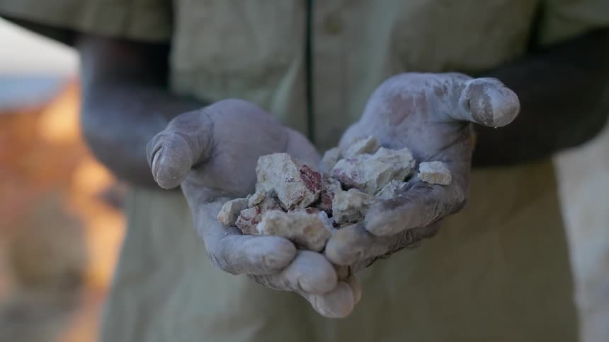 A man is holding a bunch of rocks in his hands
