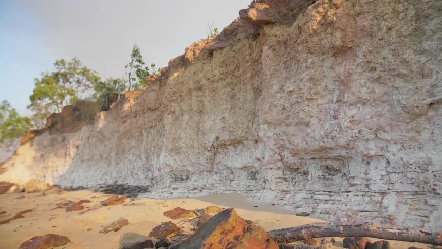 A low cliff made of pale stone on a sunny day