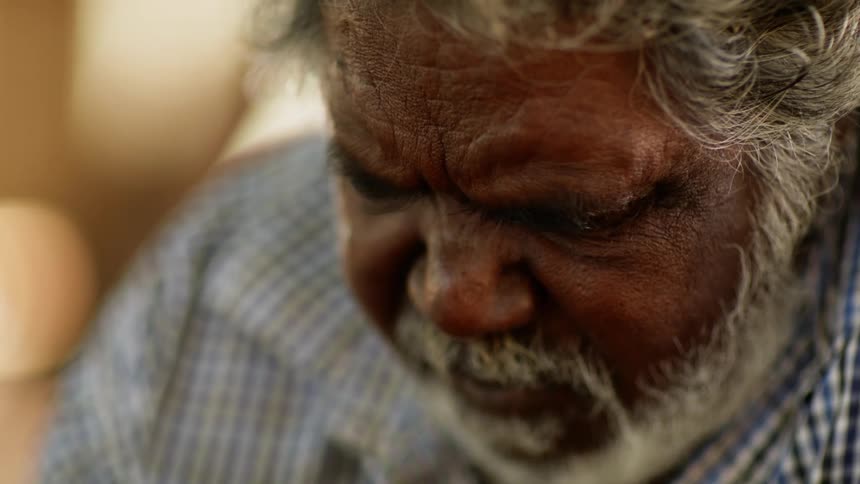 Close up of a bearded aboriginal man attentively looking at something