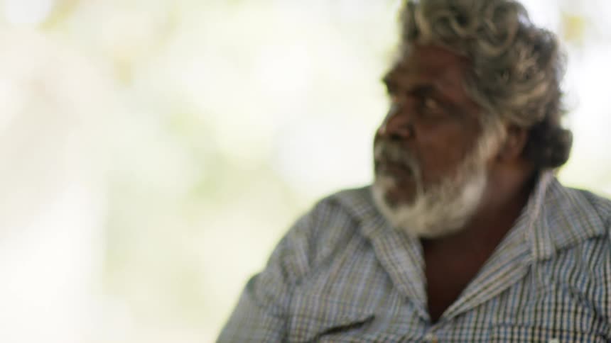 A man outside looks off in to the distance