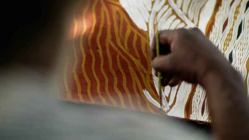 Person paints creamy white onto canvas