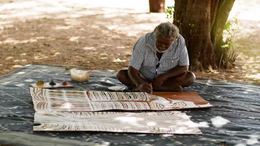 A man sitting outside painting