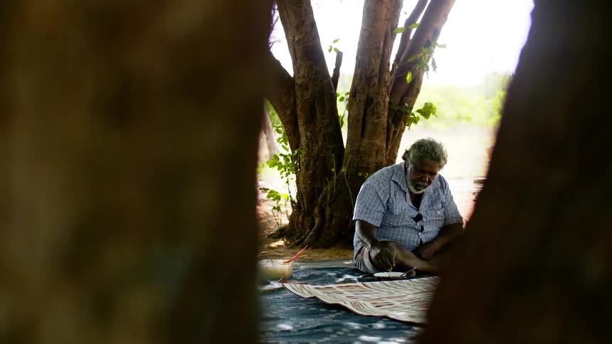 A man sits outside and paints