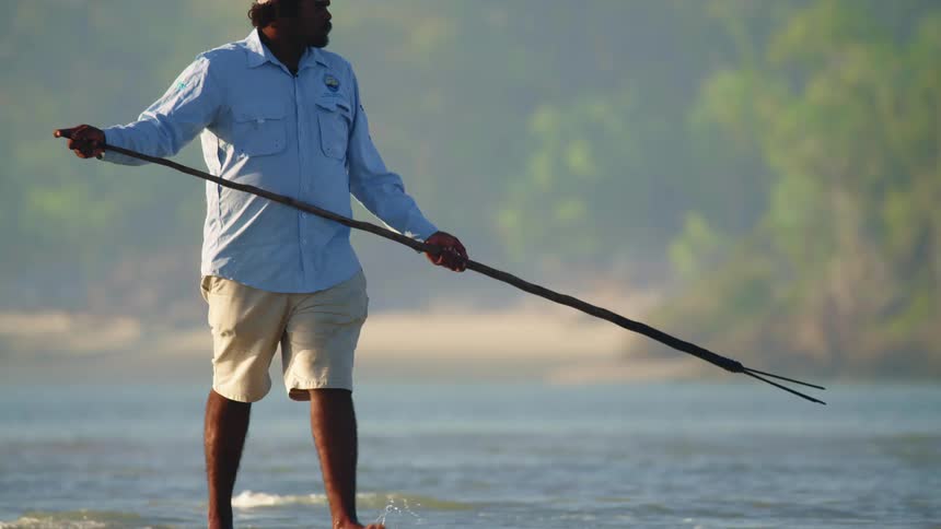 A man is spear fishing on a foggy day