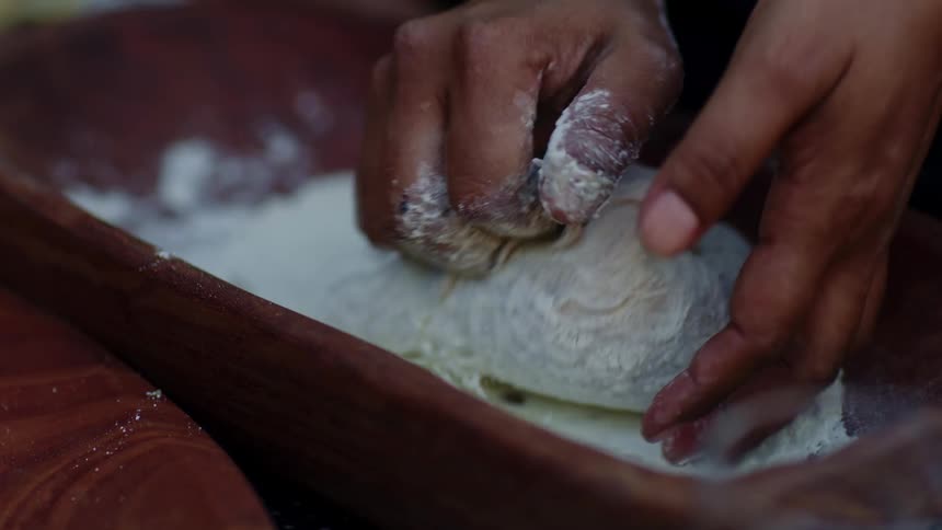Womans hands knead the dough in a bowl