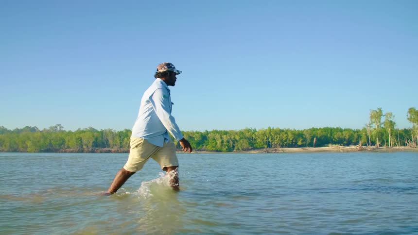 Man spearfishing in shallow water