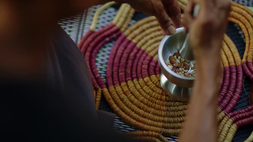 A person is crushing nuts in a mortar and pestle
