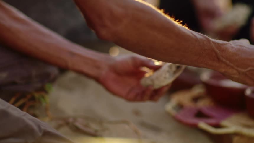 People eating damper on the beach