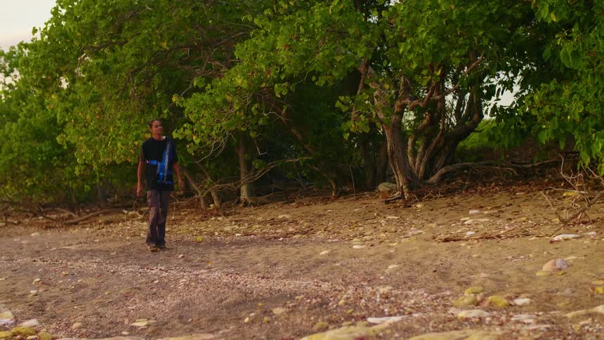 A woman walking on a path outside next to trees