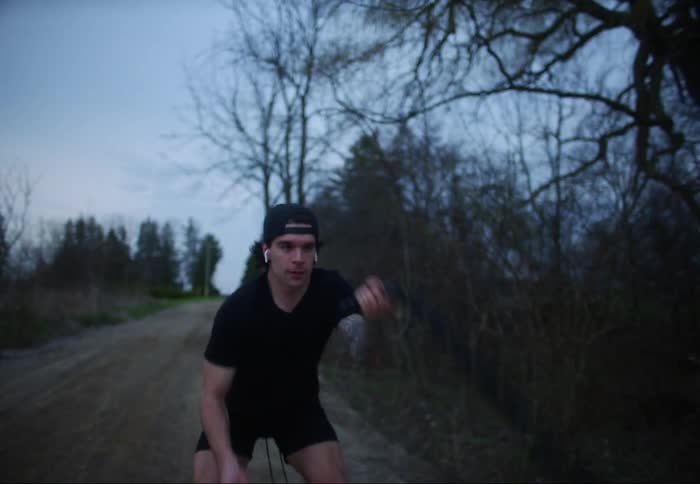A teenage boy exercises on a road in a rural area