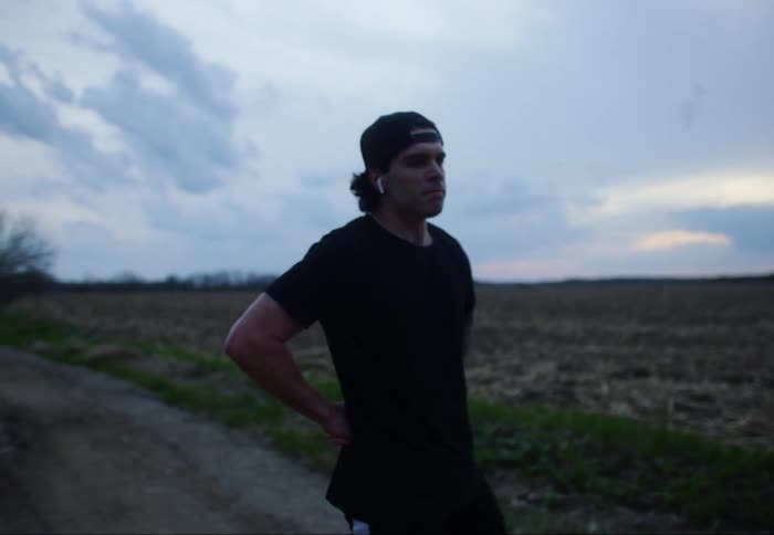 A man tries to catch his breath while pacing on the side of the road