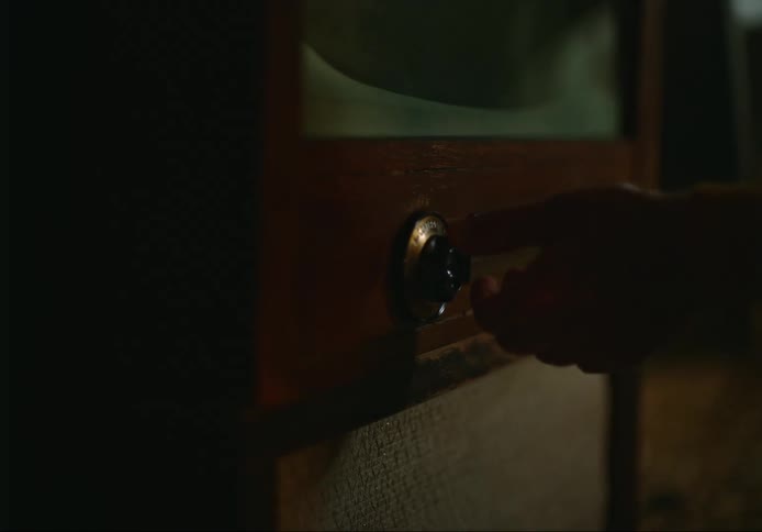 A person turning a dial on an old television set