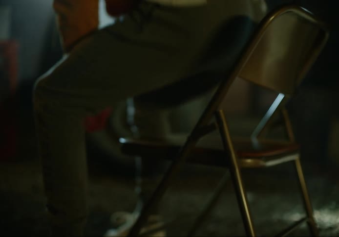 A man sitting down on a chair in a room