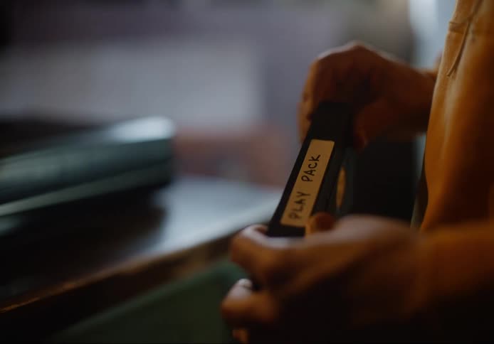 A man at home puts an old vhs tape in a video player