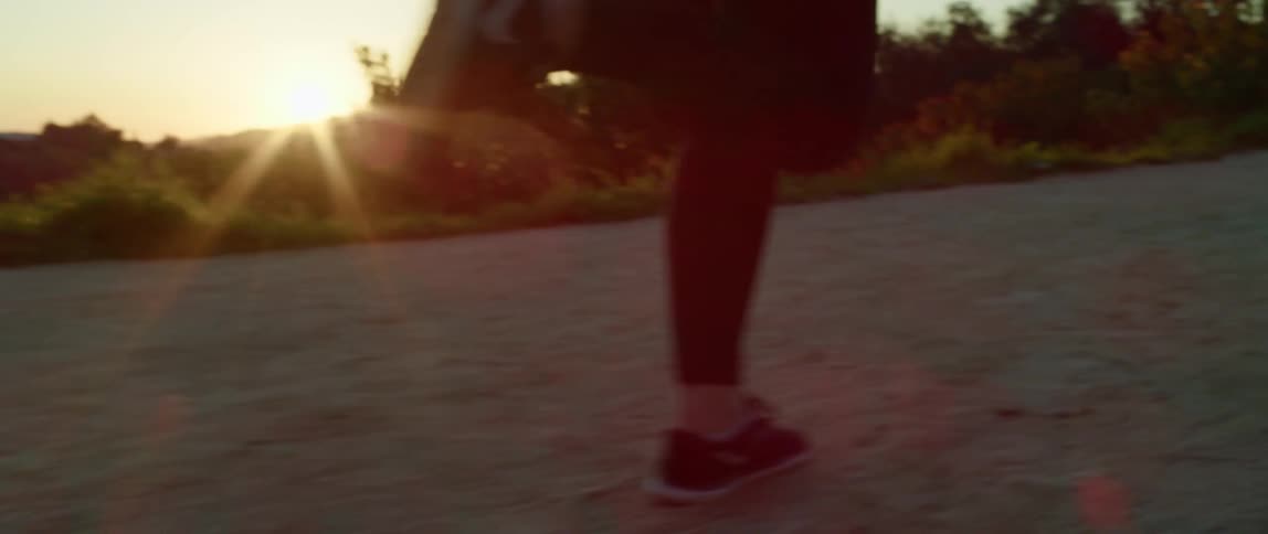 A woman running on a trail at sunset