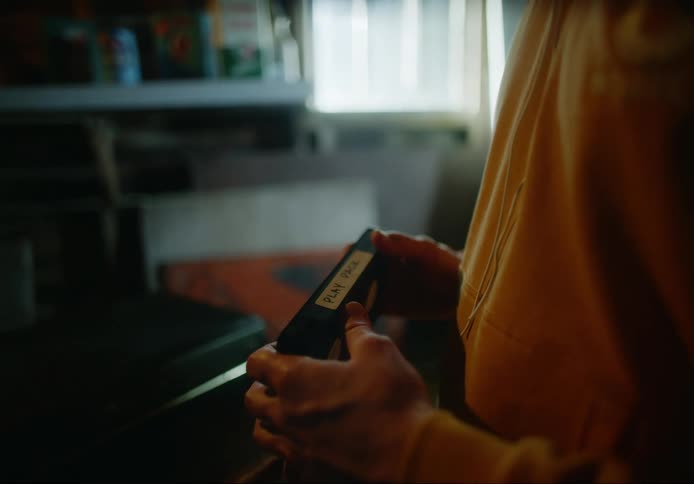 A man looks at old vhs video tapes in a house
