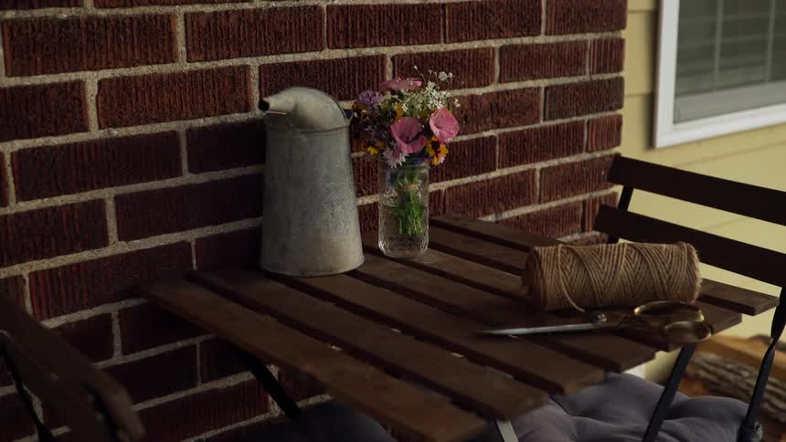 A table with scissors string and a jar with flowers