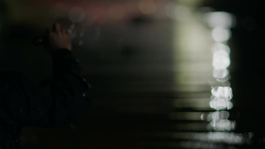 A person walking through water with a flashlight searching