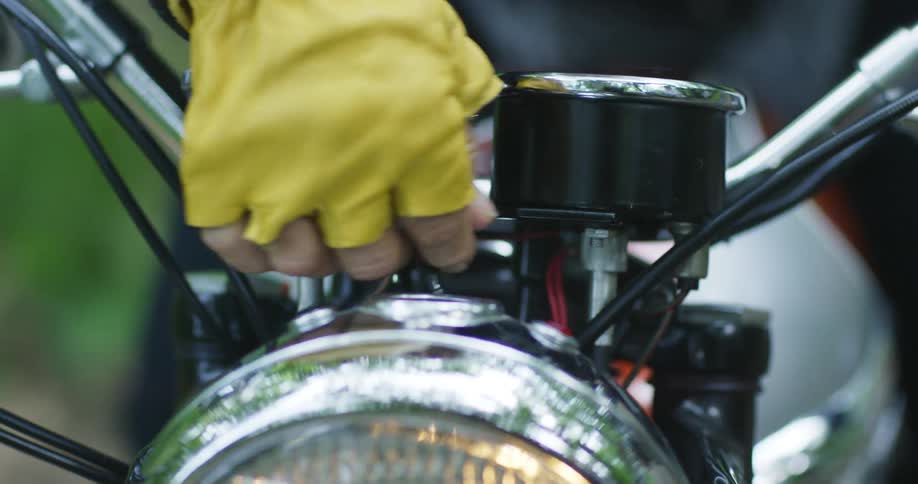 A man turns the headlights on on his motorcycle