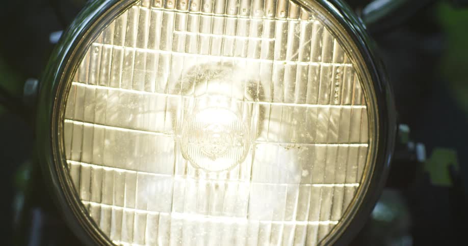 A headlight on a motorcycle turning on