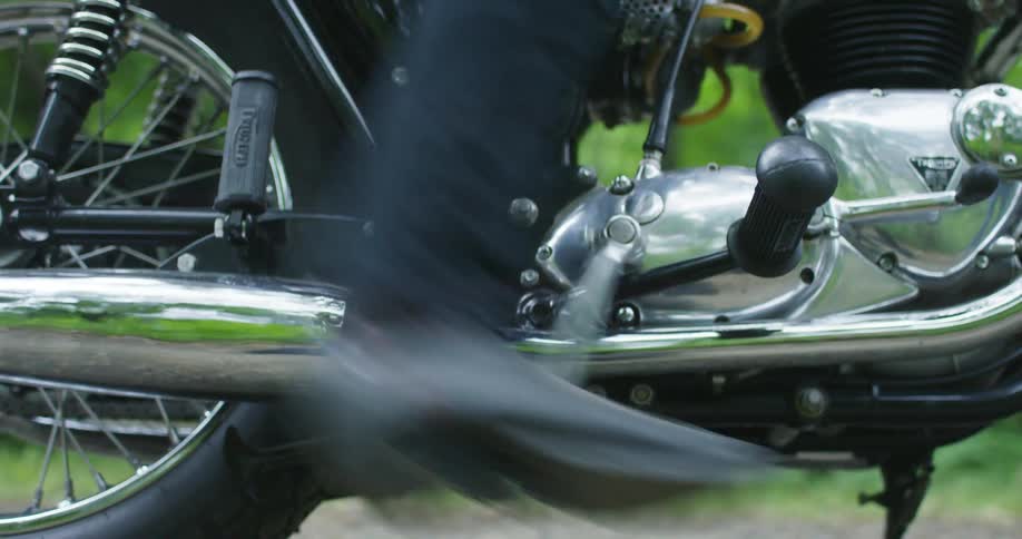Person sitting on motorcycle tries to kick start it