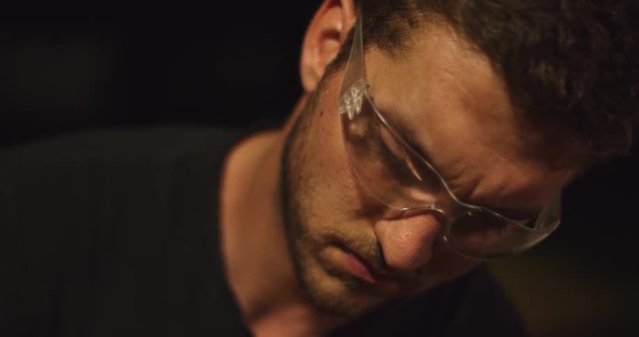 A man working in a shop wearing goggles
