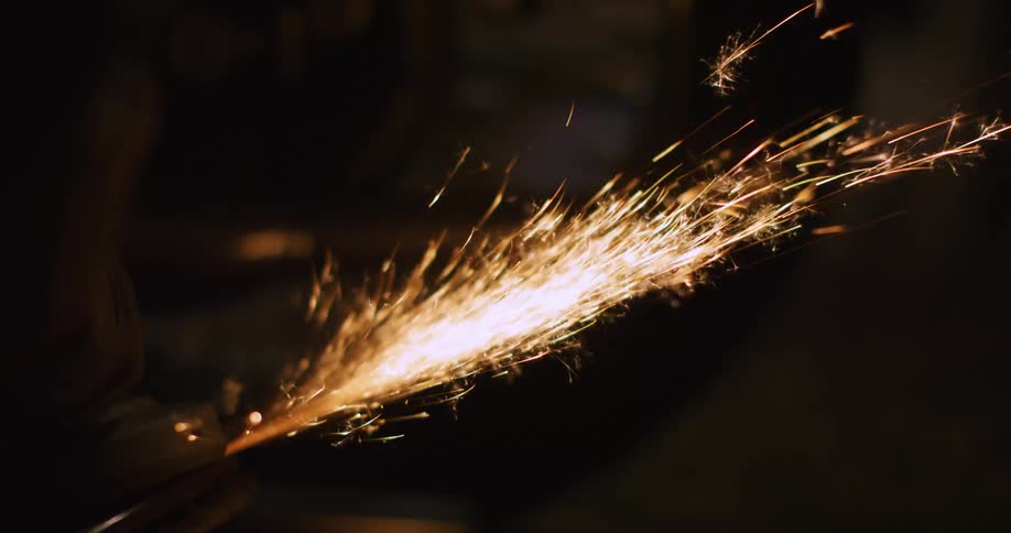 Sparks flying from a power tool in the dark