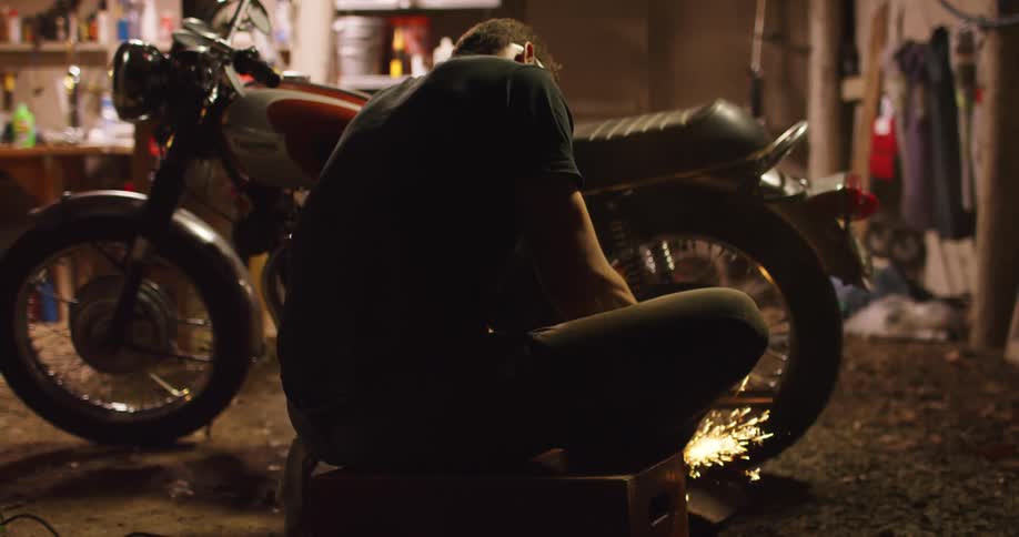 A man working on a motorcycle with a grinder