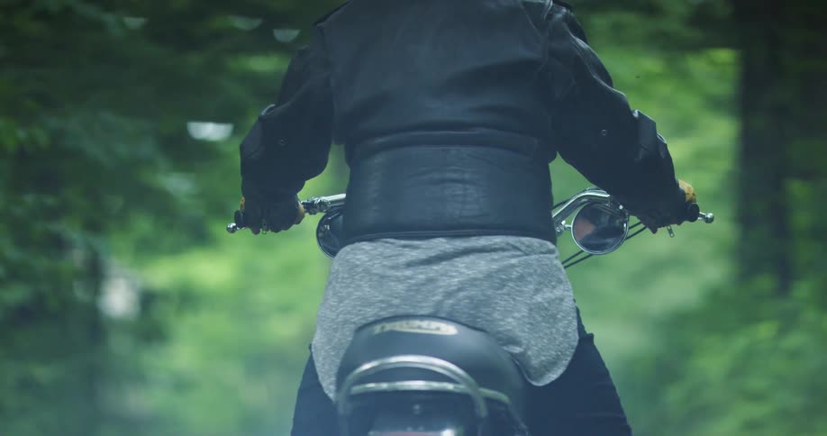 A person rides their motorcycle down the road