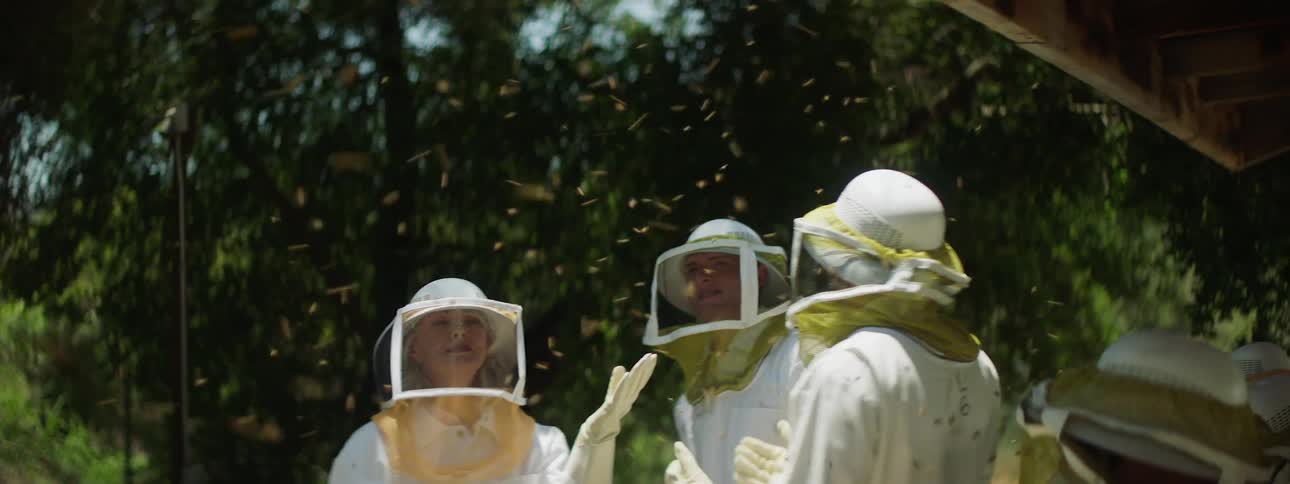 Beekeepers standing outside in a swarm of bees