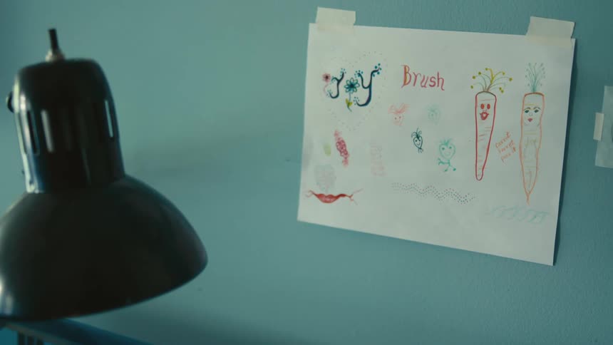 A childs drawing hangs on a wall in a home