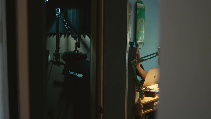 Man sitting at desk opens laptop in his room