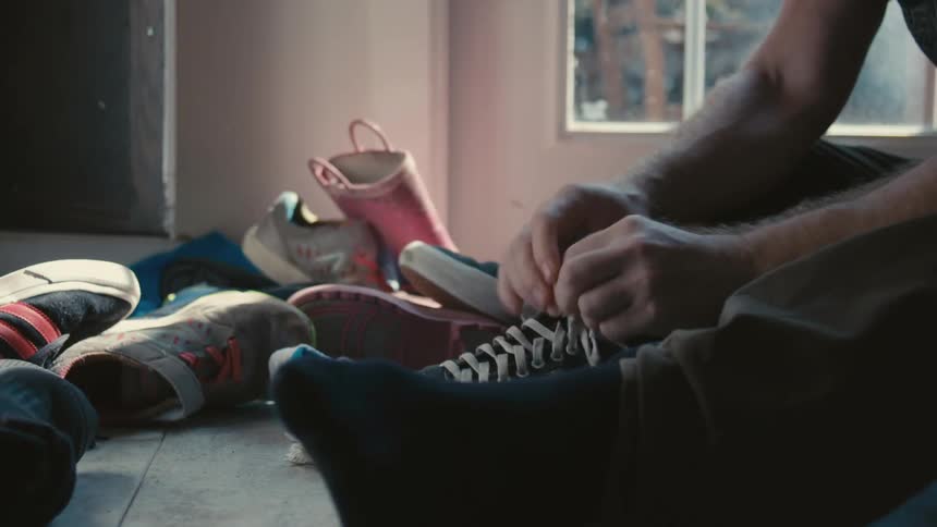 A man tying shoes sitting on the floor