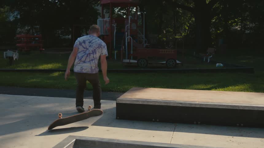 A man grinding a skateboard on a concrete pad